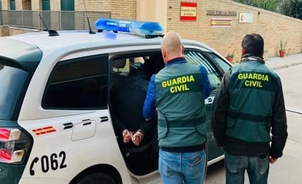 Dos guardias civiles introducen a uno de los detenidos en una unidad móvil.