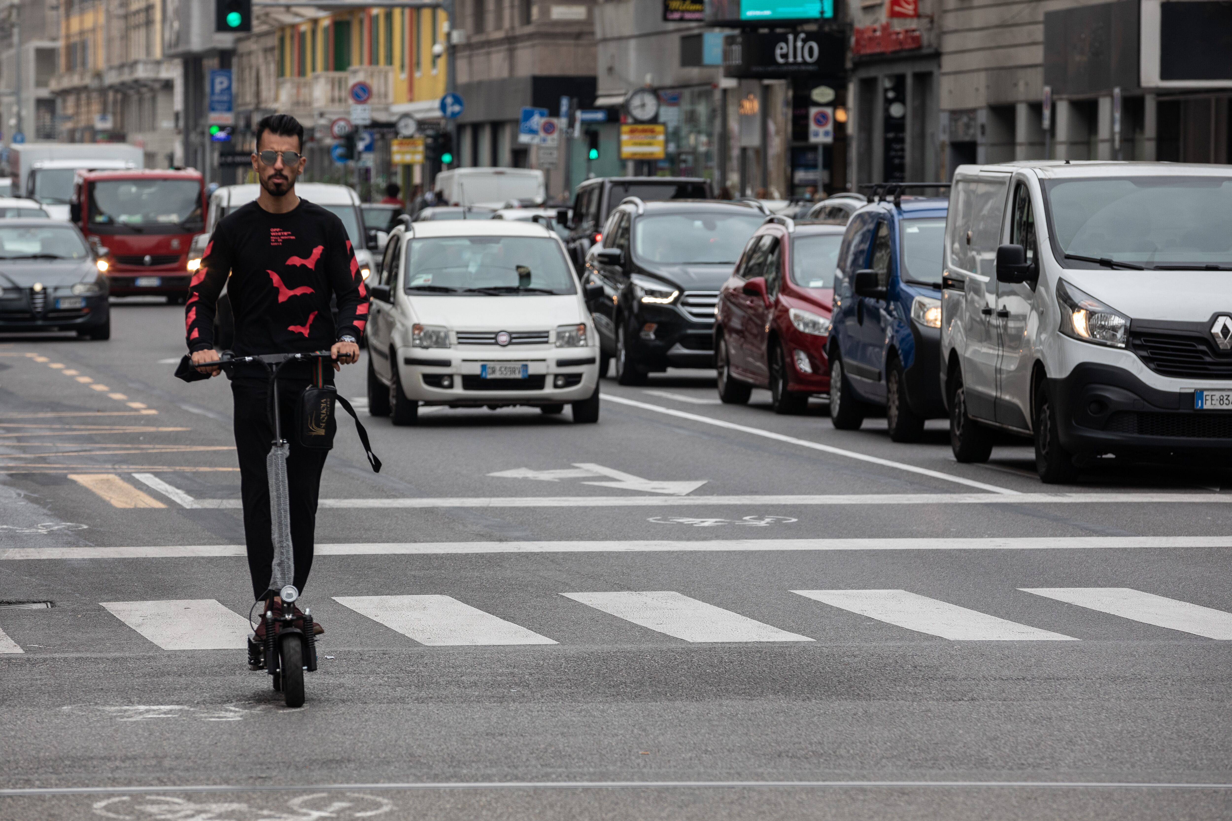 Una persona moviéndose por patinete eléctrico por Milán.