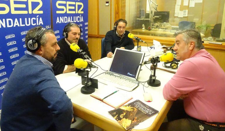 De izquierda a derecha, Paco García, director de Cruz de Guía, junto a Salvador Barba, Manolo Vega y Pepe Carrasco, autores de la enciclopedia Hermanos y Costaleros de Sevilla con la prueba de portada sobre la mesa del estudio de Radio Sevilla