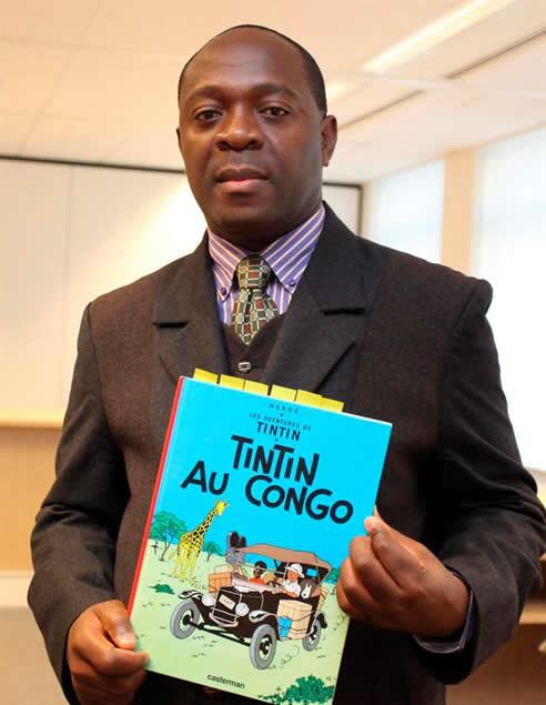 El congoleño residente en Bélgica sostiene una copia del cómic &quot;Tintín en el Congo&quot; a su llegada a un juicio en Bruselas (Bélgica)