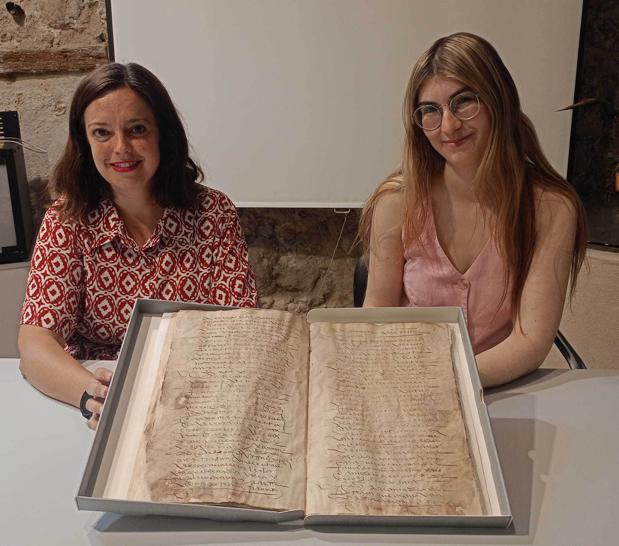 Maite Sánchez y Lucía Velasco, muestran el documento restaurado perteneciente al Archivo Municipal de Cuéllar