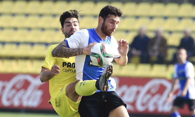 El jugador del Hércules, Rojas, defiende un balón ante Carlos Martínez, delantero del VIllarreal B