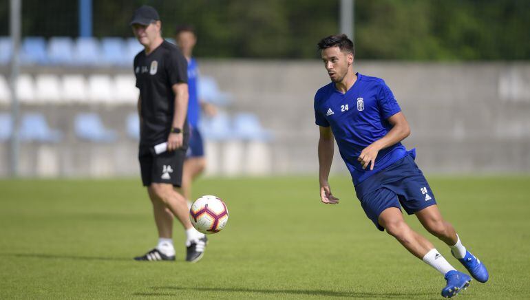 Javi Muñoz durante un entrenamiento bajo la atenta mirada de Anquela.