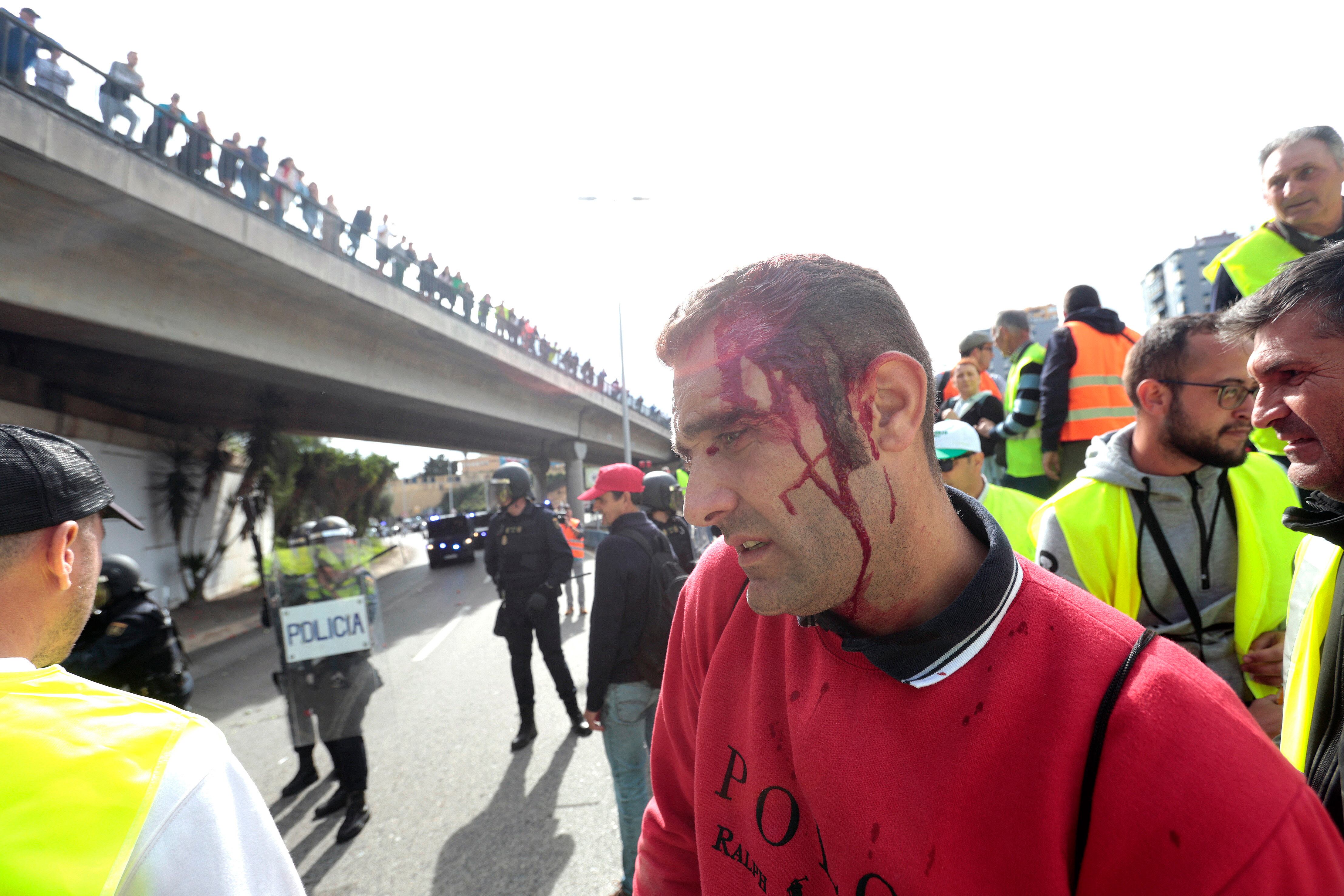 Uno de los manifestantes en la marcha de los agricultores muestra la sangre en la cabeza tras el intento de los agentes de la Policía Nacional para evitar que bloqueen el puerto de Algeciras
