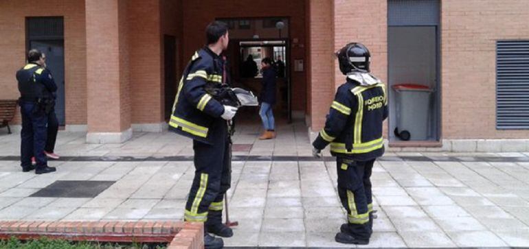 Bomberos en el portal donde está la vivienda incendiada