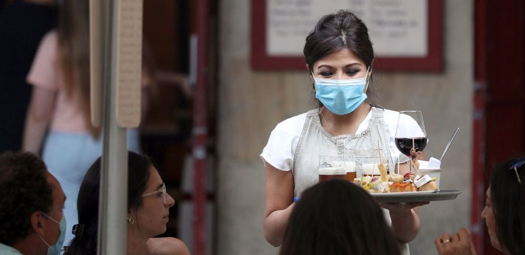 Una camarera atiende a unos clientes