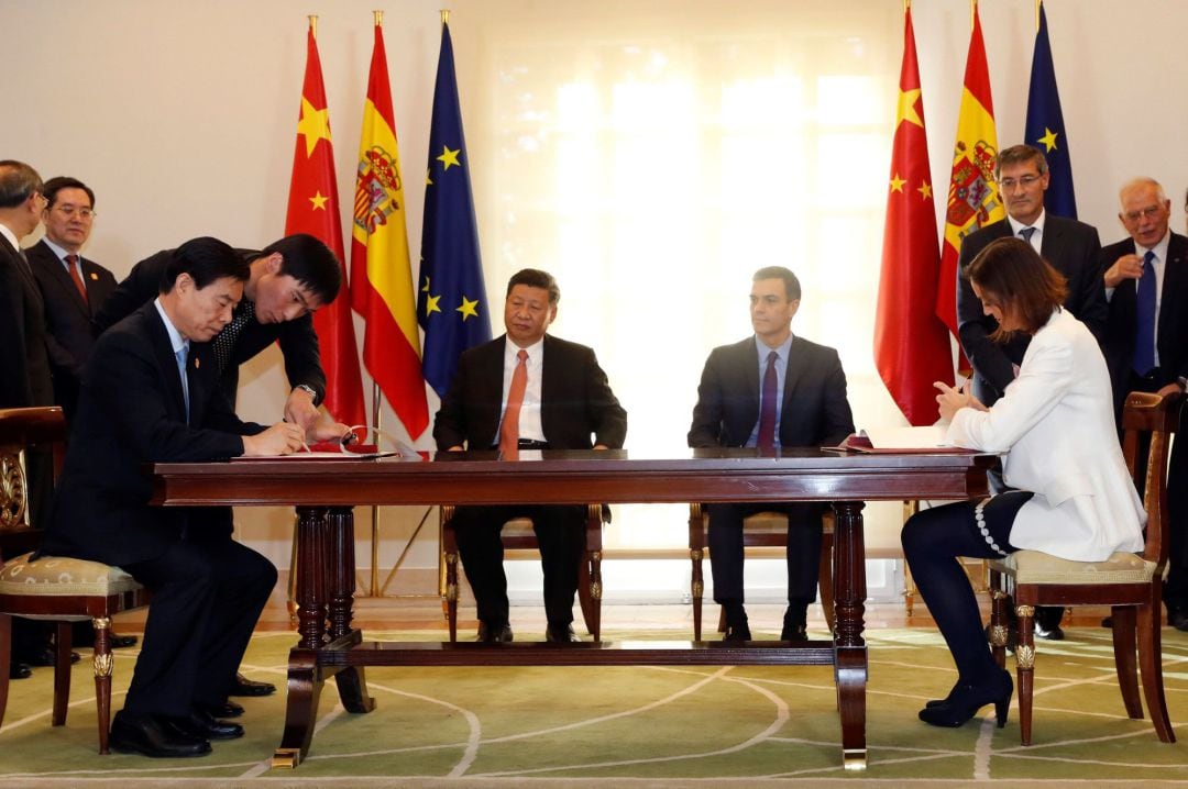 El ministro chino de Comercio, Zhong Shan (i), durante la firma un acuerdo de colaboración con la ministra española de Industria, Comercio y Turismo, Reyes Maroto (d), en presencia del presidente del Gobierno, Pedro Sánchez (2d), y del presidente de la Re