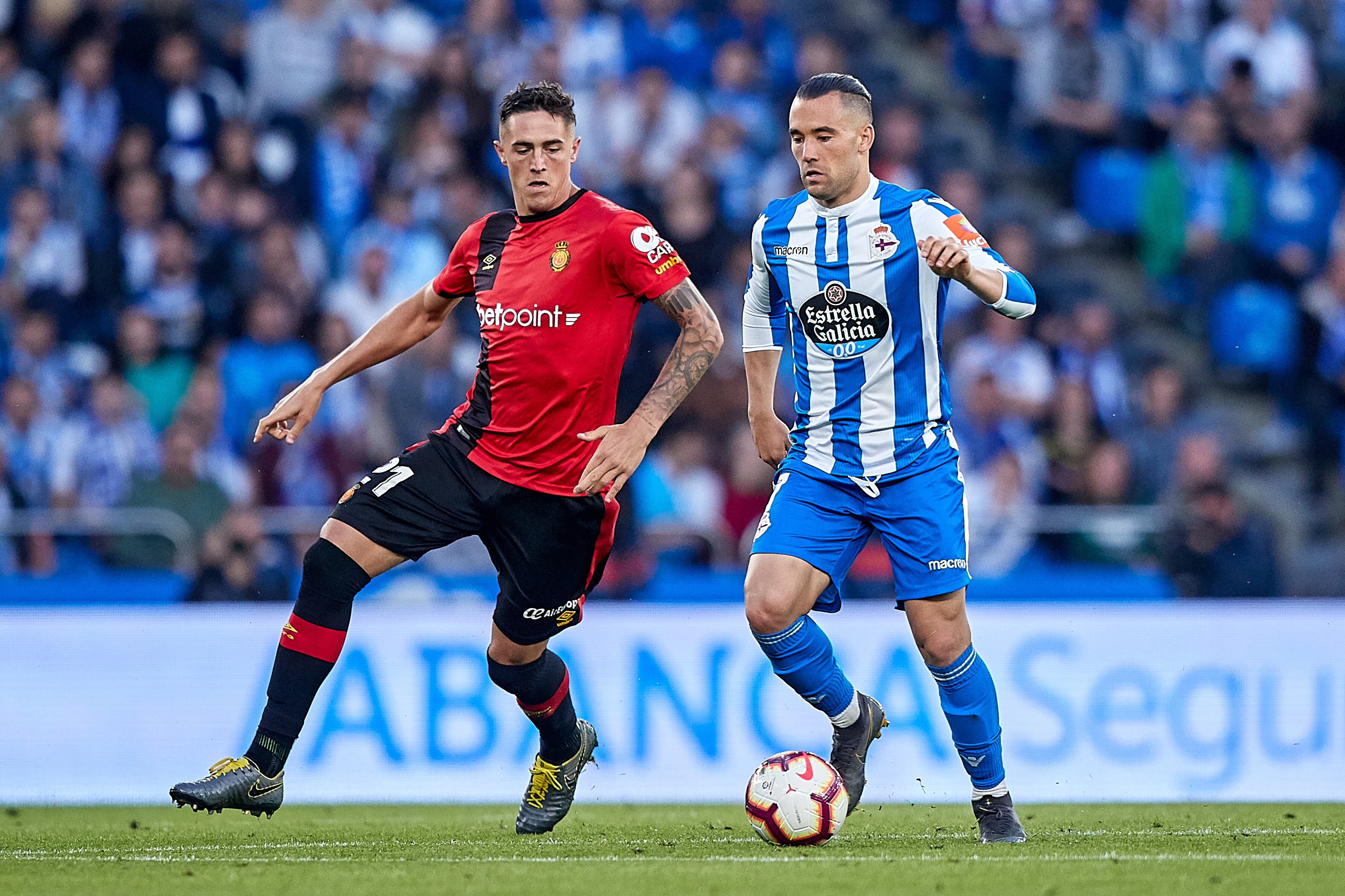LA CORUNA, SPAIN - JUNE 20: Quique Gonzalez of Deportivo de La Coruna is challenged by Antonio Raillo of RCD Mallorca during the La Liga 123 play off match between Deportivo De La Coruna and RCD Mallorca at Estadio Abanca-Riazor on June 20, 2019 in La Coruna, Spain. (Photo by Quality Sport Images/Getty Images)
