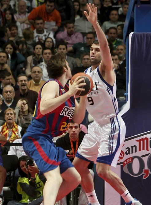 El pívot del Real Madrid Felipe Reyes bloquea el lanzamiento del ala-pívot esloveno del Regal FC Barcelona Erazem Lorbek