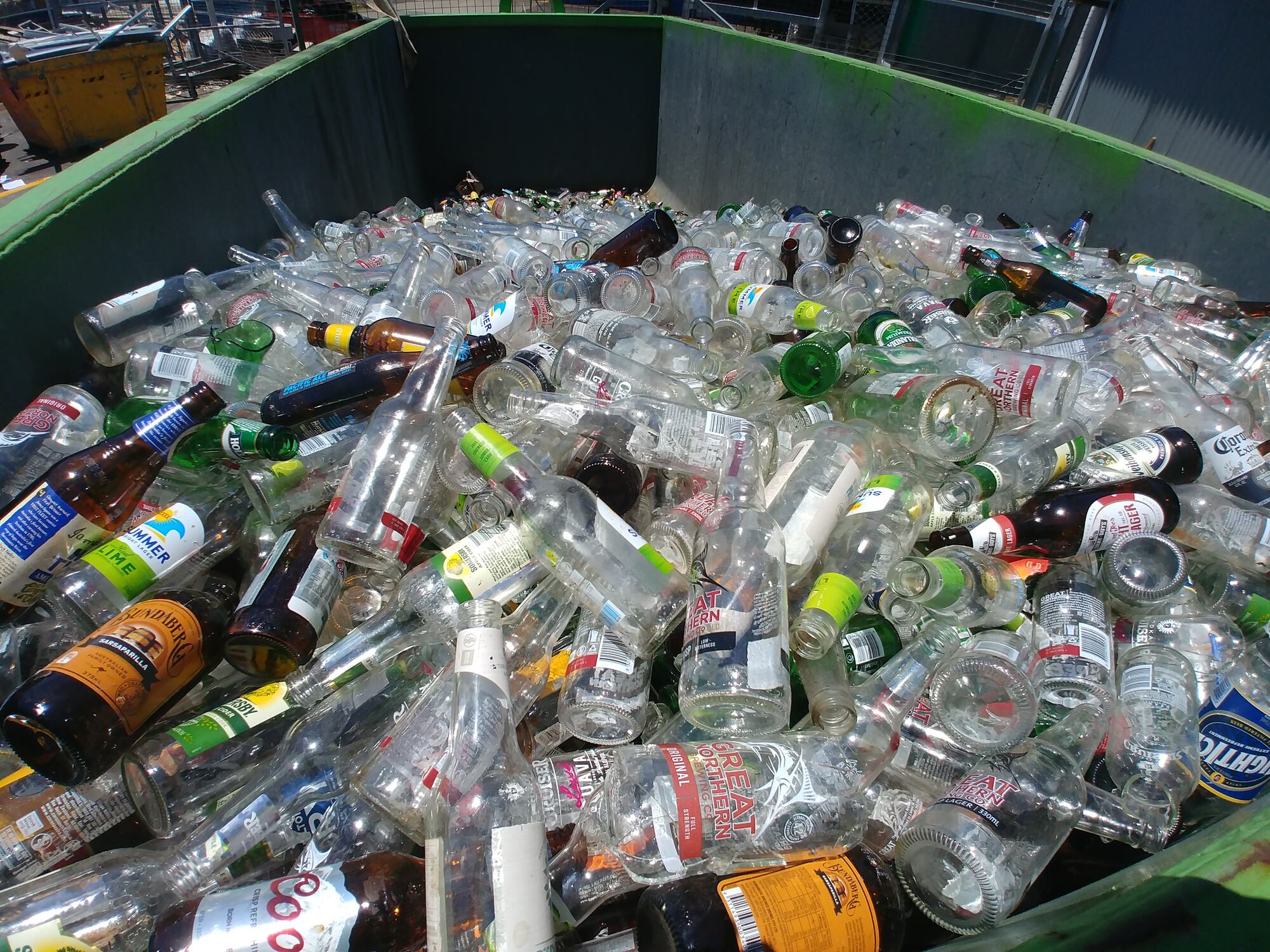 Botellas de vidrio recicladas en un contenedor.