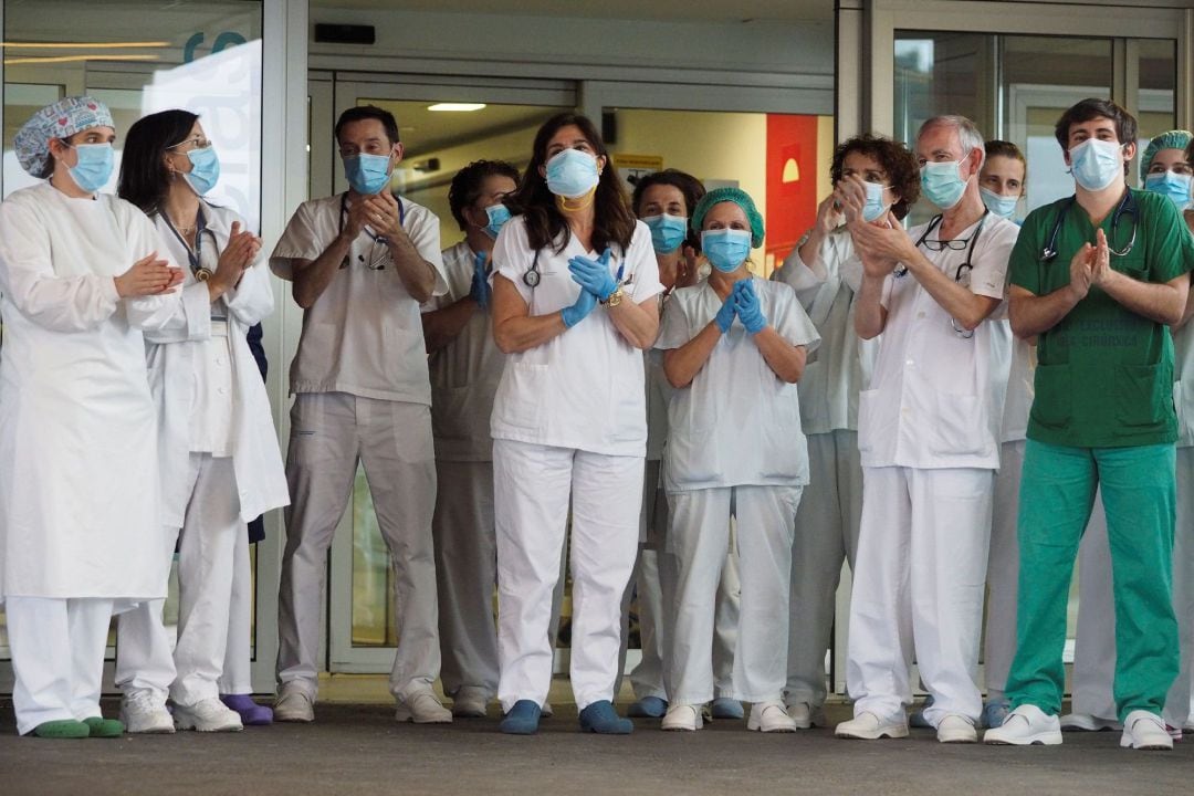 Personal sanitario devuelven los aplausos durante el homenaje a la labor de los servicios sanitarios con la crisis del coronavirus, este jueves