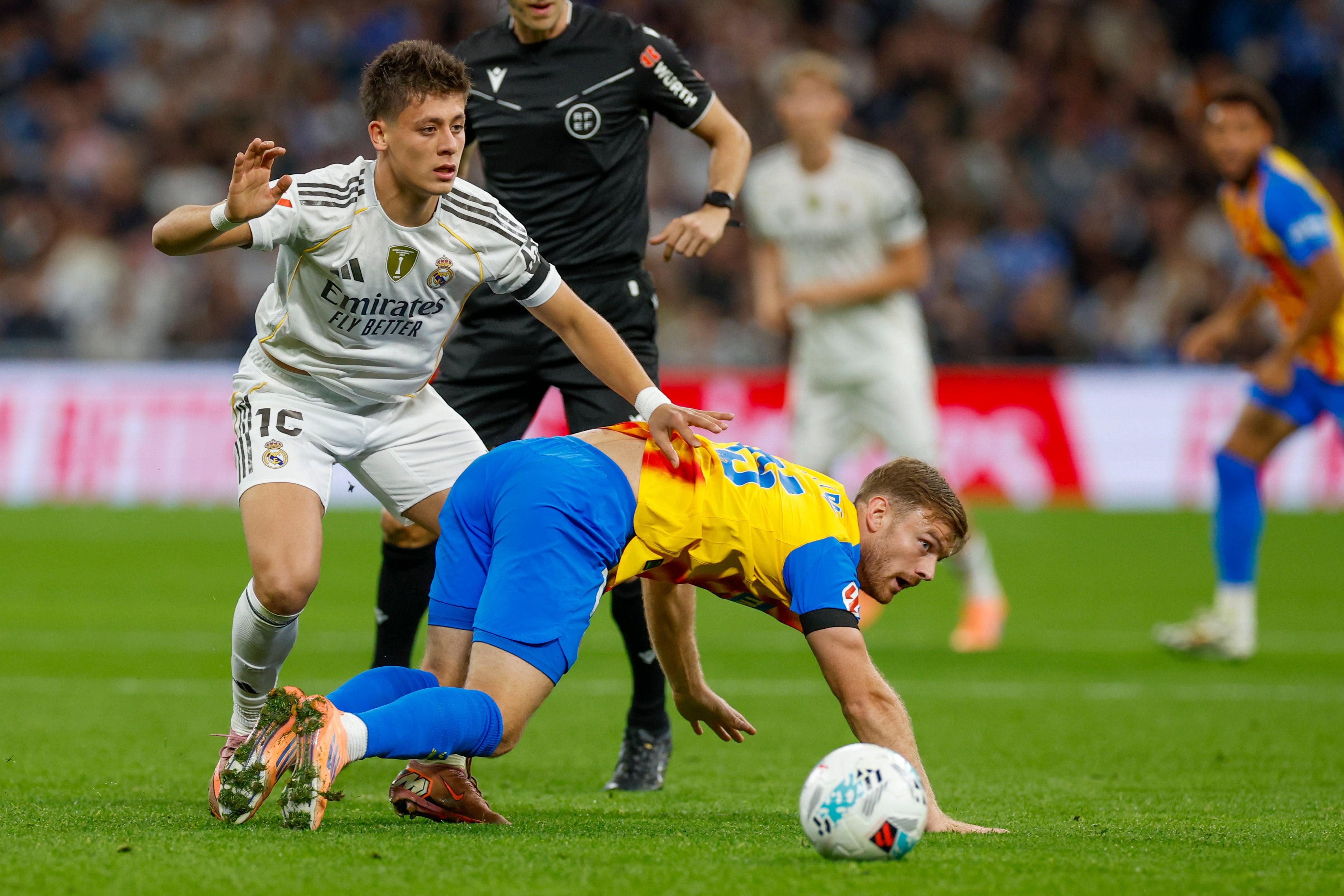 MADRID, 01/11/2025.- El centrocampista turco del Real Madrid Arda Guler (i) lucha con Lucas Beltrán, del Valencia, durante el partido de la jornada 11 de LaLiga que Real Madrid y Valencia CF disputan este sábado en el estadio Santiago Bernabéu. EFE/Javier Lizón