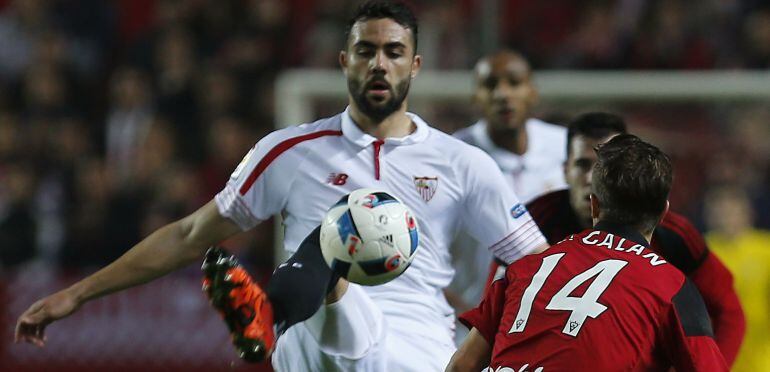 El centrocampista del Sevilla Vicente Iborra golpea el balón ante el defensa del Mirandés Ernesto Galán, 