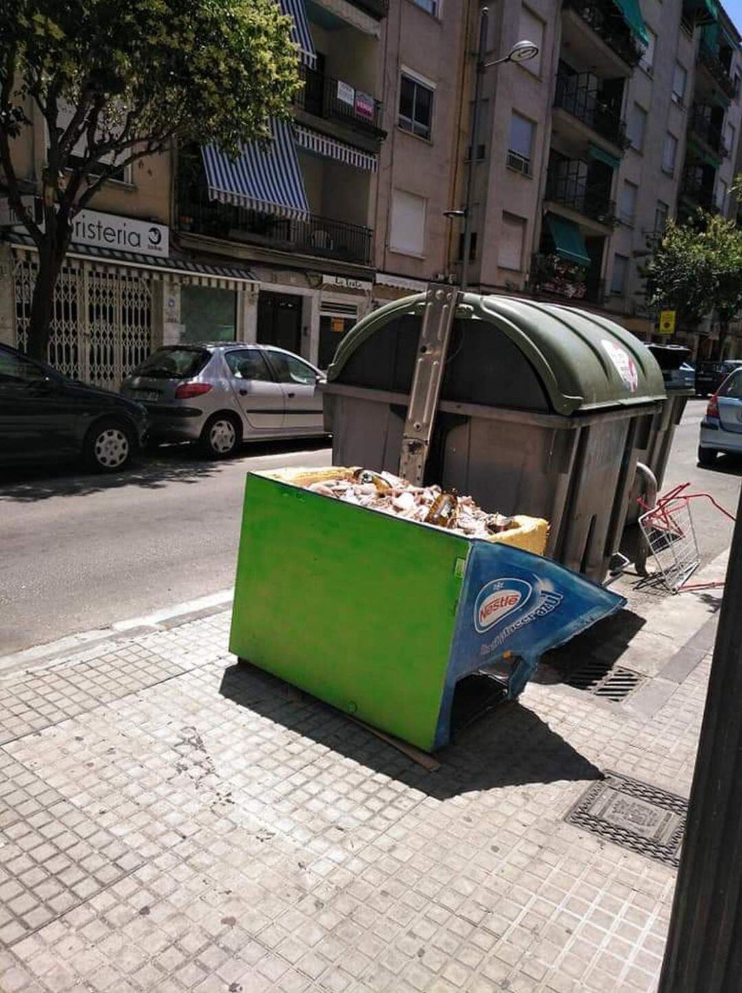 Práctica ilegal en Gandia de tirar escombros y neveras en un contenedor de la ciudad. 