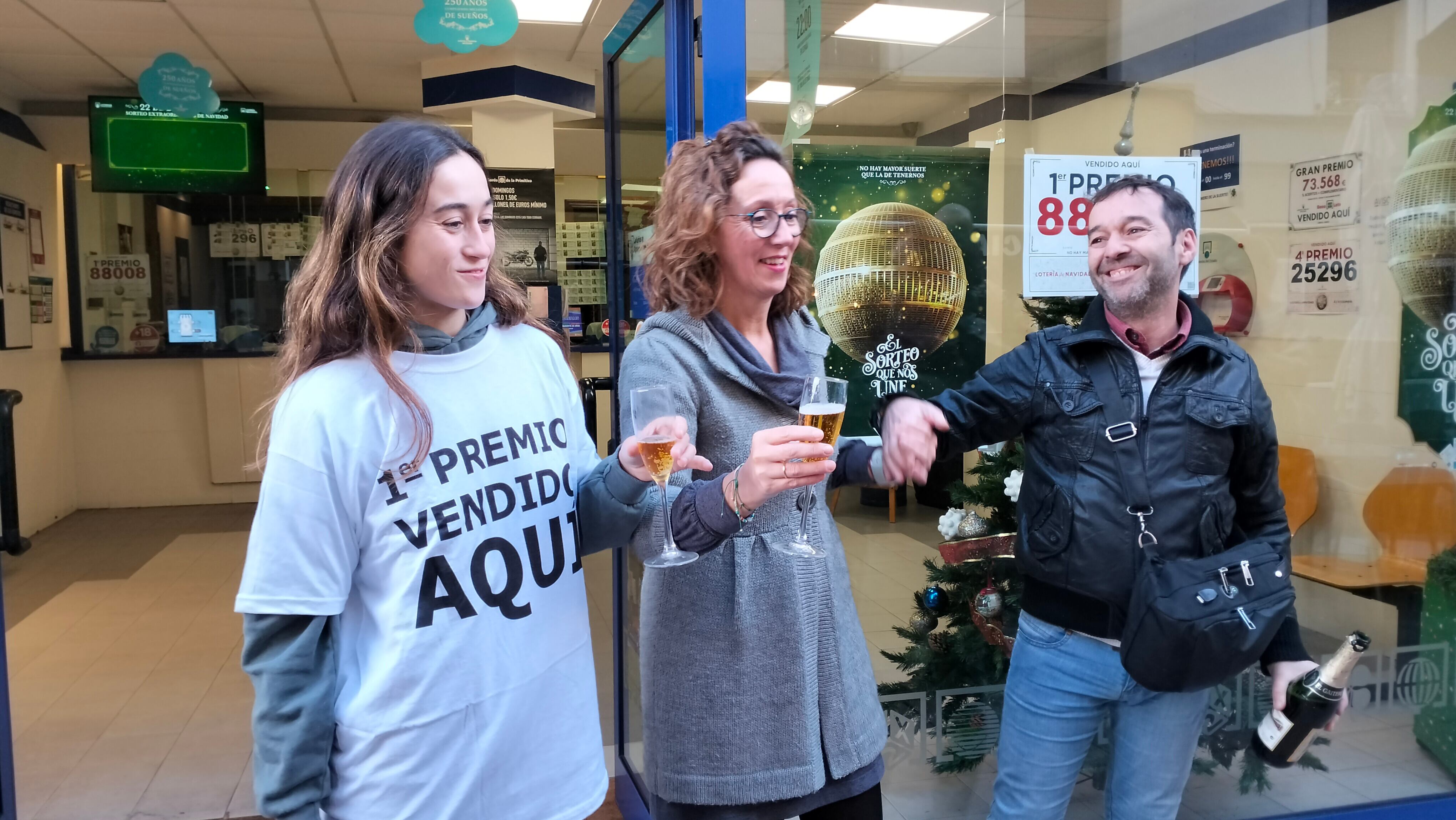 La lotera, Marta paredes, brinda con su familia a la puerta de la Administración