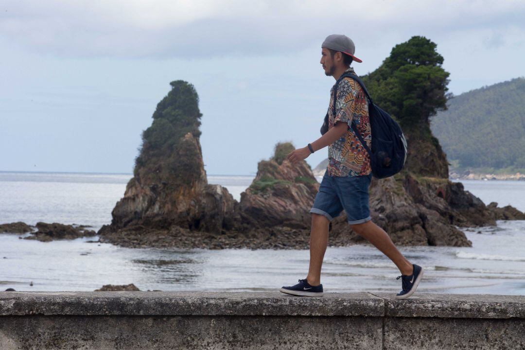 Un joven pasea por el paseo marítimo de Viveiro en A Mariña.