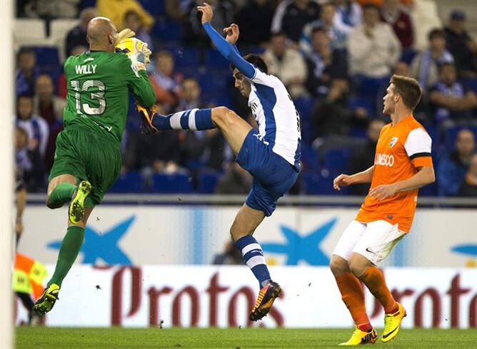 El centrocampista del Espanyol Manuel Lanzarote (c) intenta un remate ante el portero argentino del Málaga Wilfredo Daniel Caballero