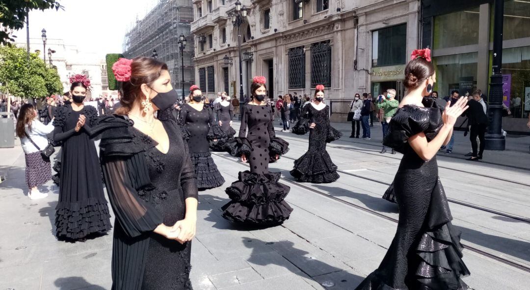 Una treintena de mujeres, en primer término la artista Joana Jiménez, han lucido trajes de flamenca de color negro durante la movilización