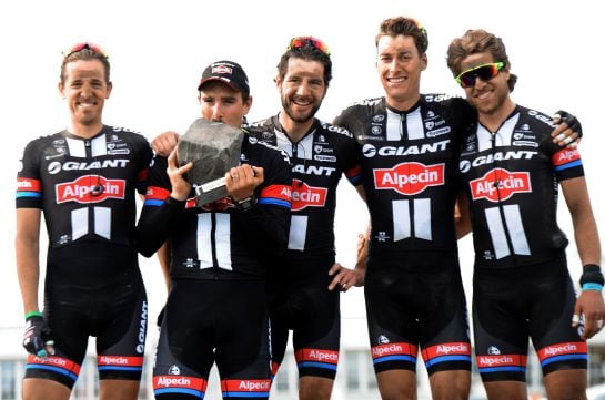 Team Giant-Alpecin German cyclist John Degenkolb (2L) celebrates with teammates on the podium after winning the 113th edition of the Paris-Roubaix Paris-Roubaix one-day classic cycling race in Roubaix on April 12, 2015. AFP PHOTO / FRANCOIS LO PRESTI