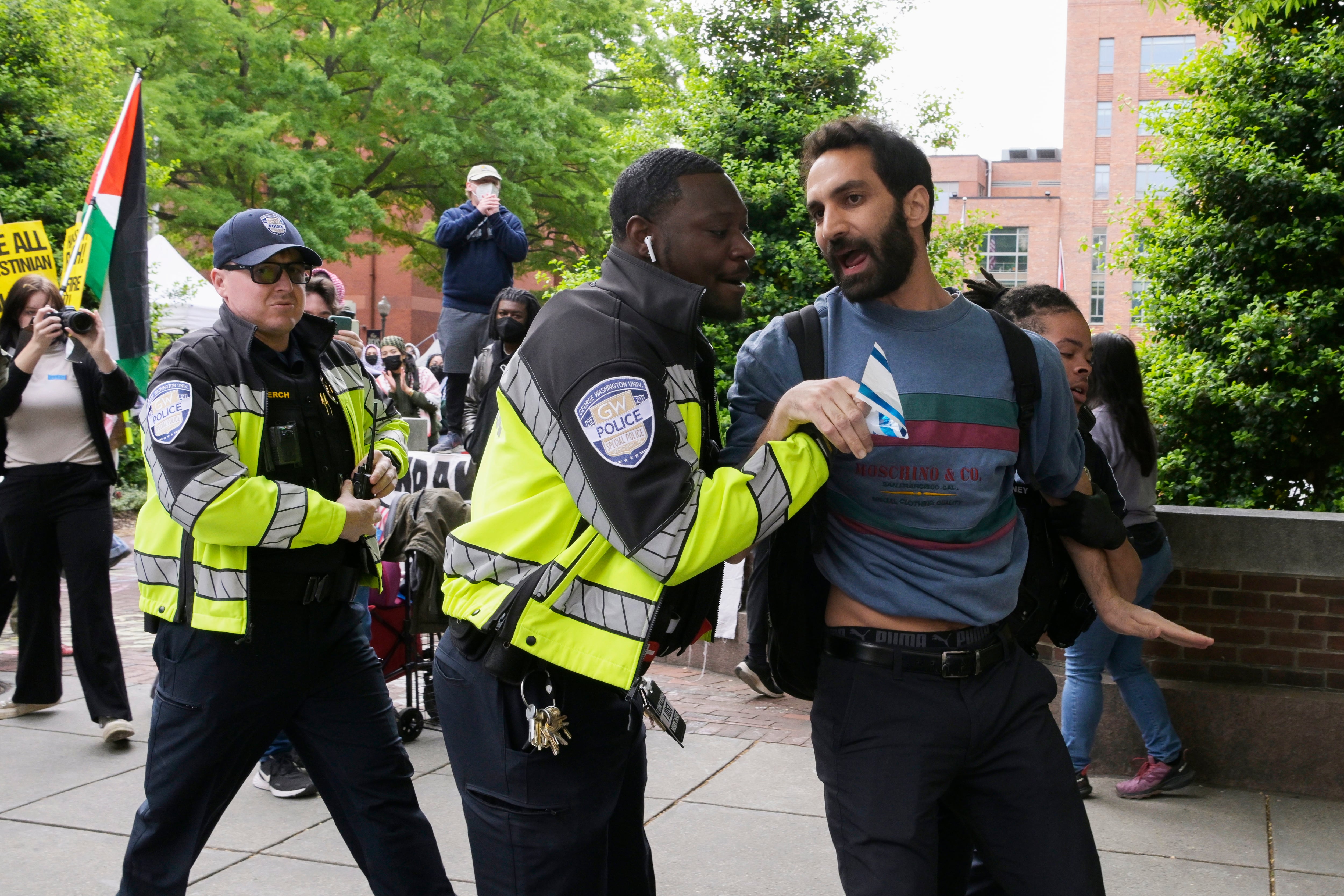 Agentes de policía alejan a un manifestante proisraelí que trató de irrumpir en el campamento de los manifestantes propalestinos de la Coalición de Estudiantes por la Justicia en Palestina este jueves, en el patio de la Universidad George Washington en Washington (EEUU). 