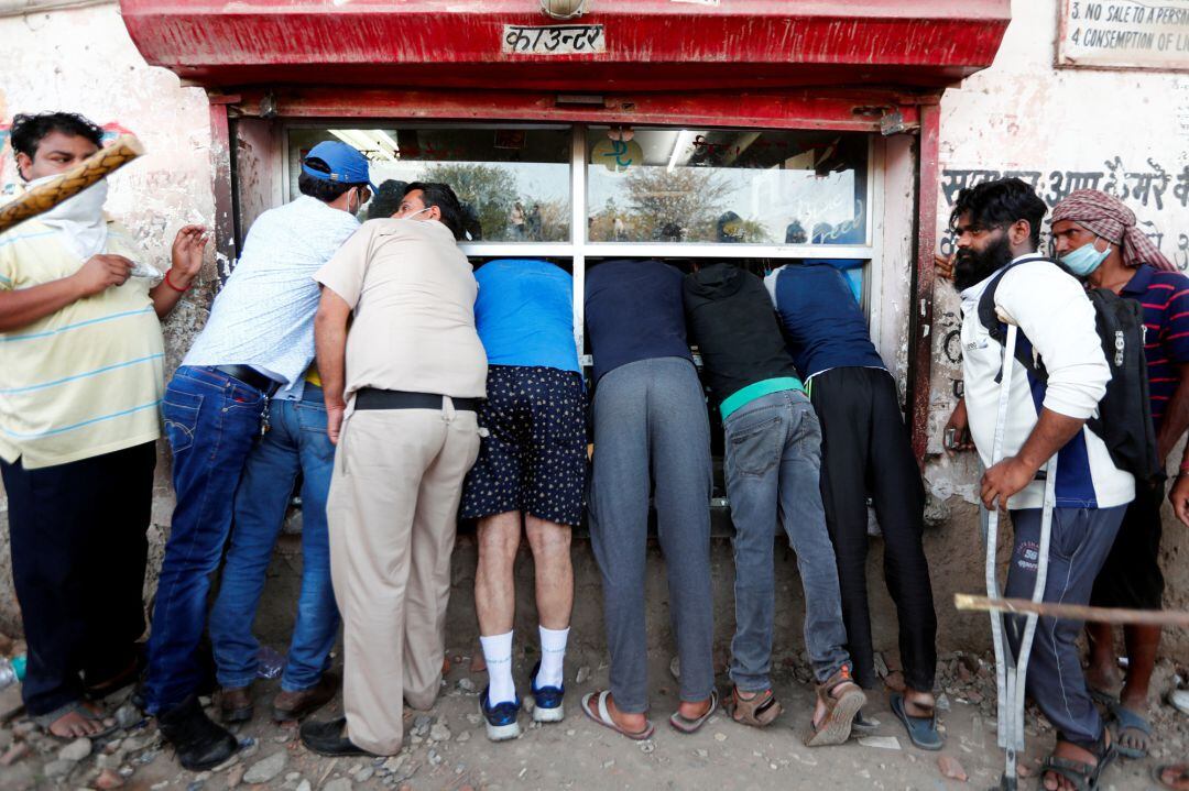 Un grupo de gente agolpado en una licorería de Nueva Delhi, India