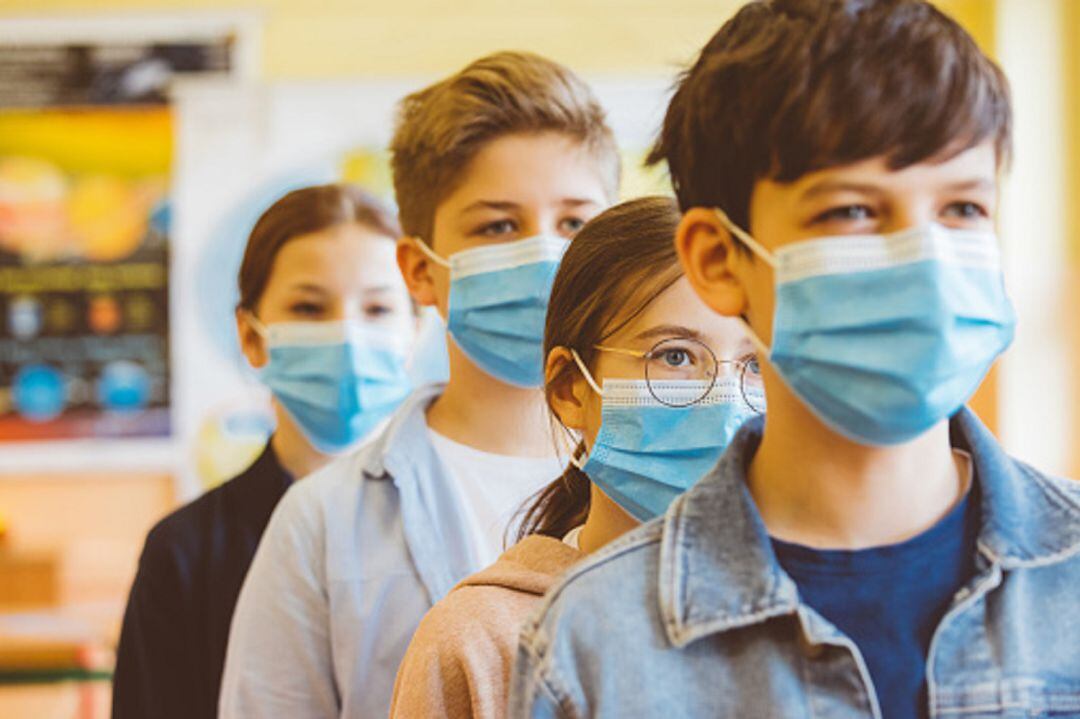 Estudiantes con mascarilla haciendo fila