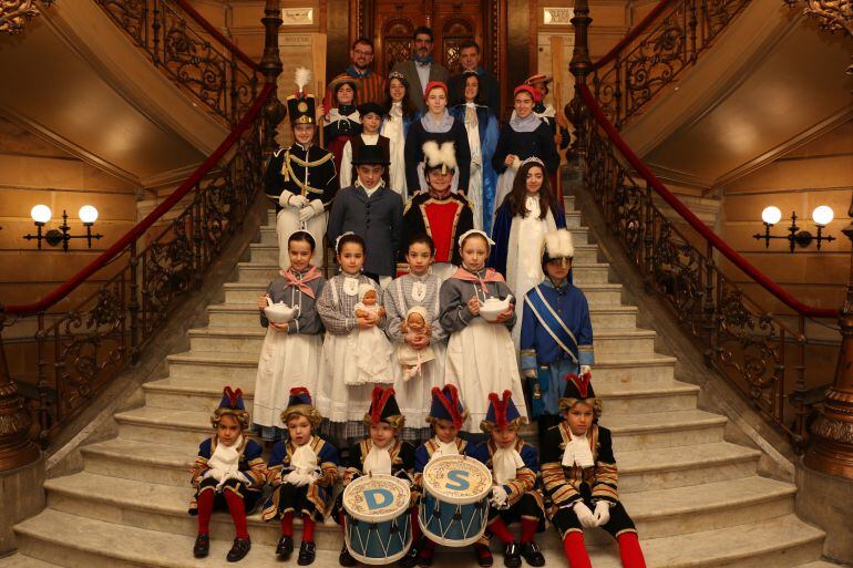 Los manos de la tamborrada infantil posan en las escalintas del Ayuntamiento de San Sebastiánjunto al alcalde, Eneko Goia.