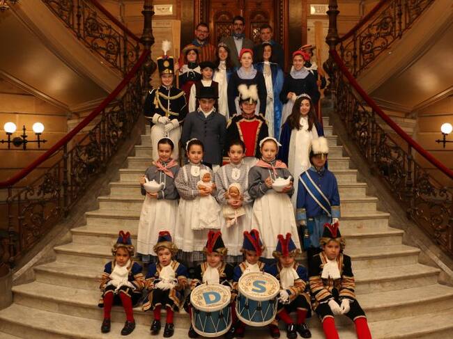 Los manos de la tamborrada infantil posan en las escalintas del Ayuntamiento de San Sebastiánjunto al alcalde, Eneko Goia.