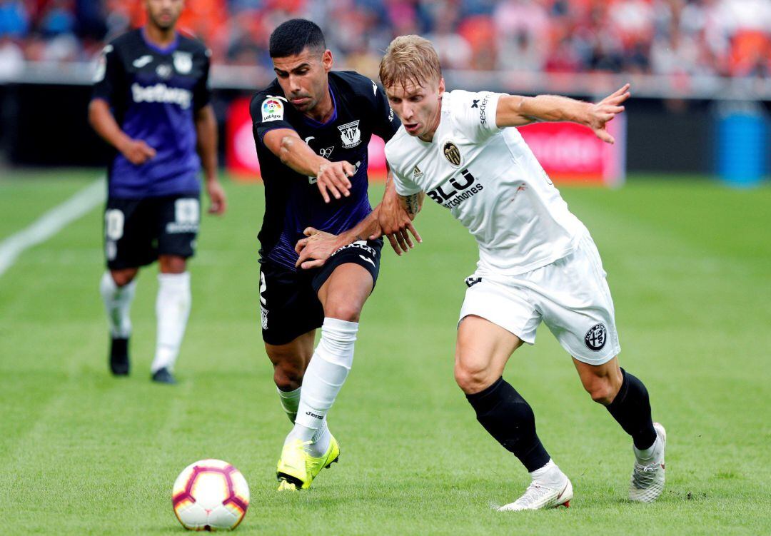 El centrocampista danés del Valencia, Daniel Wass (d), disputa el balón con el defensa del Leganés, Juanfran Moreno (i), durante el partido de la novena jornada de Liga que ambos equipos disputaron en el estadio de Mestalla, en Valencia.