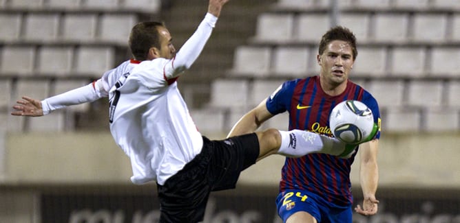 El delantero del L?Hospitalet, David Prats, intenta controlar el balón ante el defensor del F. C. Barcelona, Fontás, durante el encuentro correspondiente a la ida de los dieciseisavos de la Copa del Rey, que ambos equipos disputan esta noche en el estadio