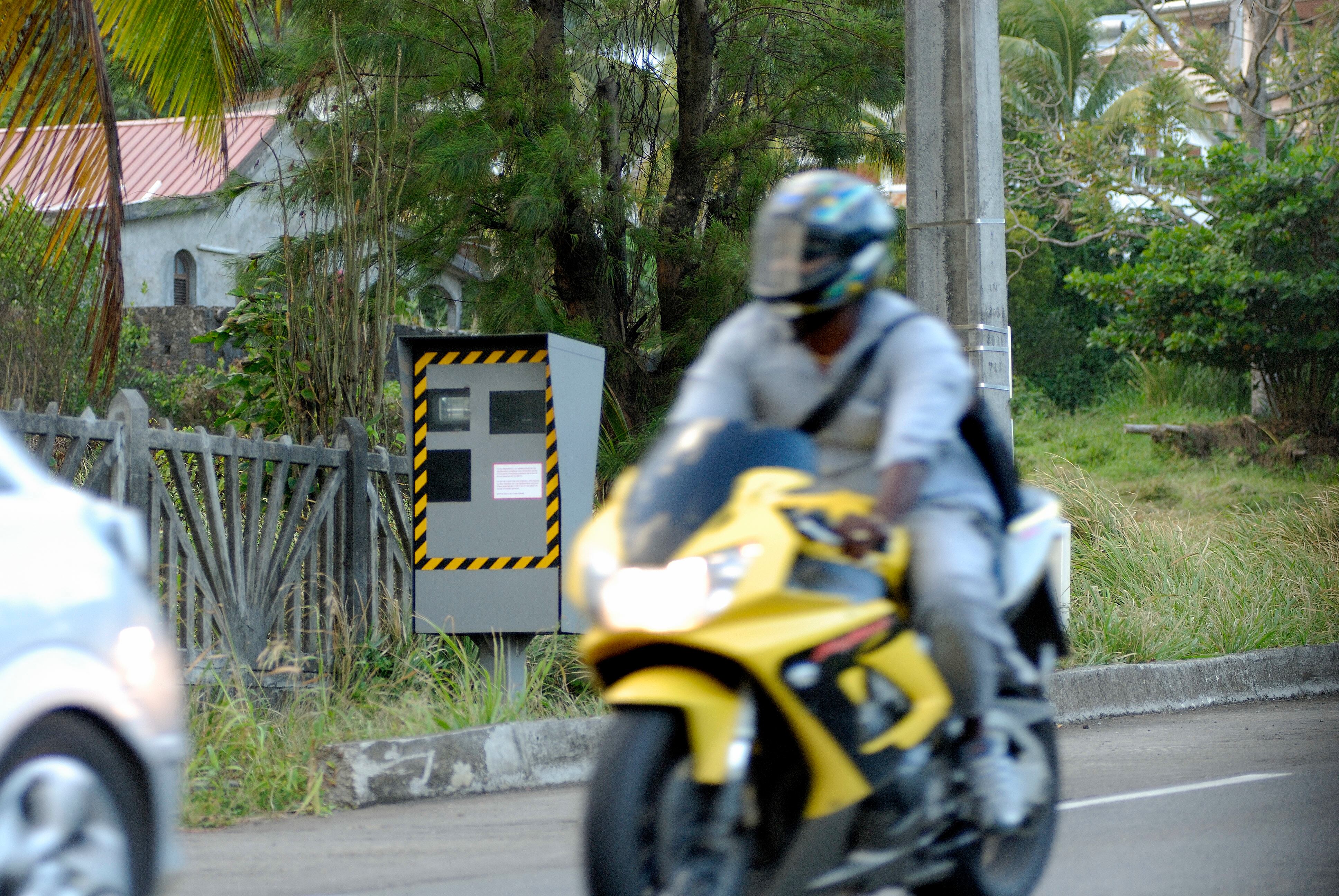 Un motorista pasando por delante de un radar.