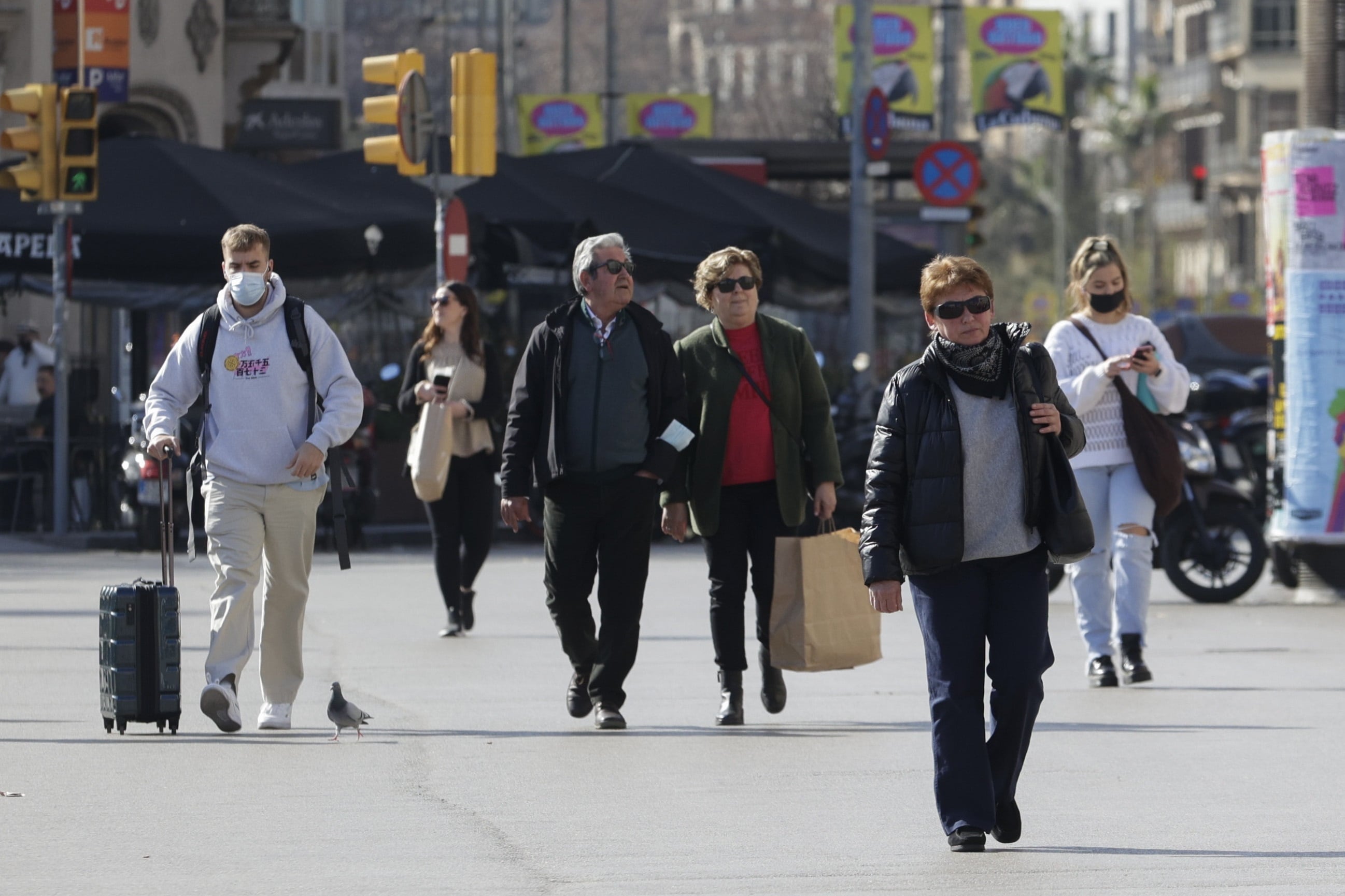 GRAFCAT2584. BARCELONA (ESPAÑA), 10/02/2022.- Varias personas pasean por el centro de Barcelona, este jueves en que la sexta ola sigue disminuyendo en Cataluña, pero aún con más de 12.000 contagios diarios durante la última semana y una media de 38 fallecidos por covid cada día, por lo que las autoridades sanitarias piden no bajar la guardia, pese a que hoy ha decaído la obligación de llevar mascarilla al aire libre si no hay aglomeraciones.EFE/Quique García
