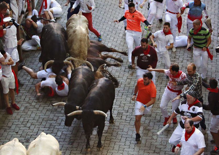 Los toros de la ganadería gaditana de Núñez del Cuvillo enfilan junto a mansos y corredores el Callejón hacia el interior de la Plaza de Toros durante el quinto encierro de los Sanfermines 2018 que ha resultado emocionante y vistoso con huecos entre los