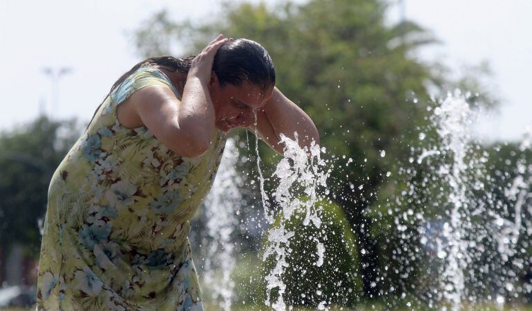 Una mujer se refresca en una de las fuentes de la ciudad debido a las altas temperaturas que se registran en Córdoba, dentro de la ola de calor que se registra en casi toda España.