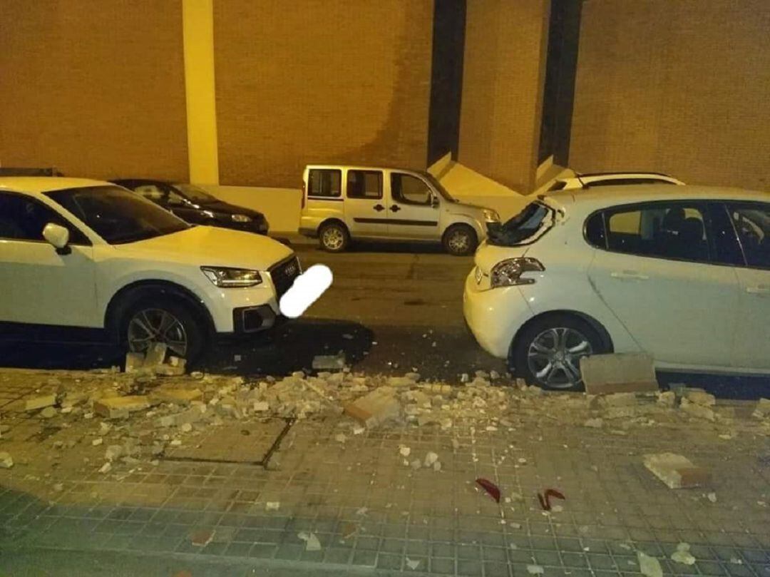 Estado en el que quedó la calle, con cascotes en el suelo y un vehículo con daños materiales por el suceso