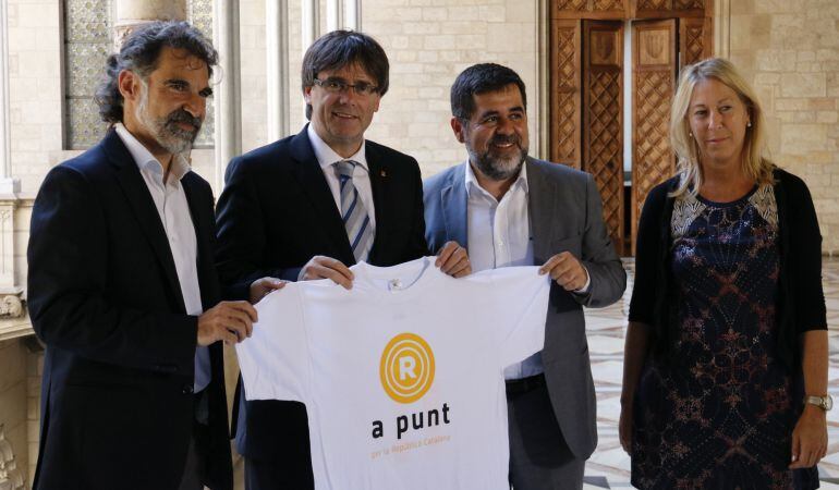 El president de la Generalitat, Carles Puigdemont, i la portaveu del Govern, Neus Munté, es fotografien amb la samarreta de la manifestació de la Diada amb els presidents de l&#039;ANC i Òmnium, Jordi Sànchez i Jordi Cuixart a Palau.