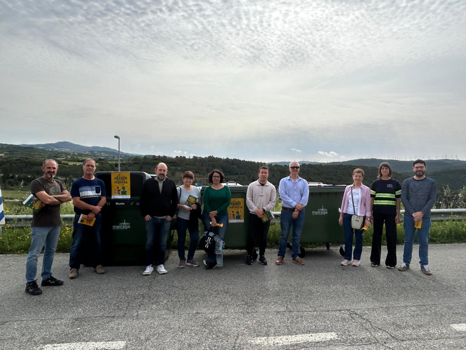 El presidente de Mairaga, Carlos Alcuaz, y  representantes municipales junto a los nuevos contenedores de fracción resto presentados en Pueyo