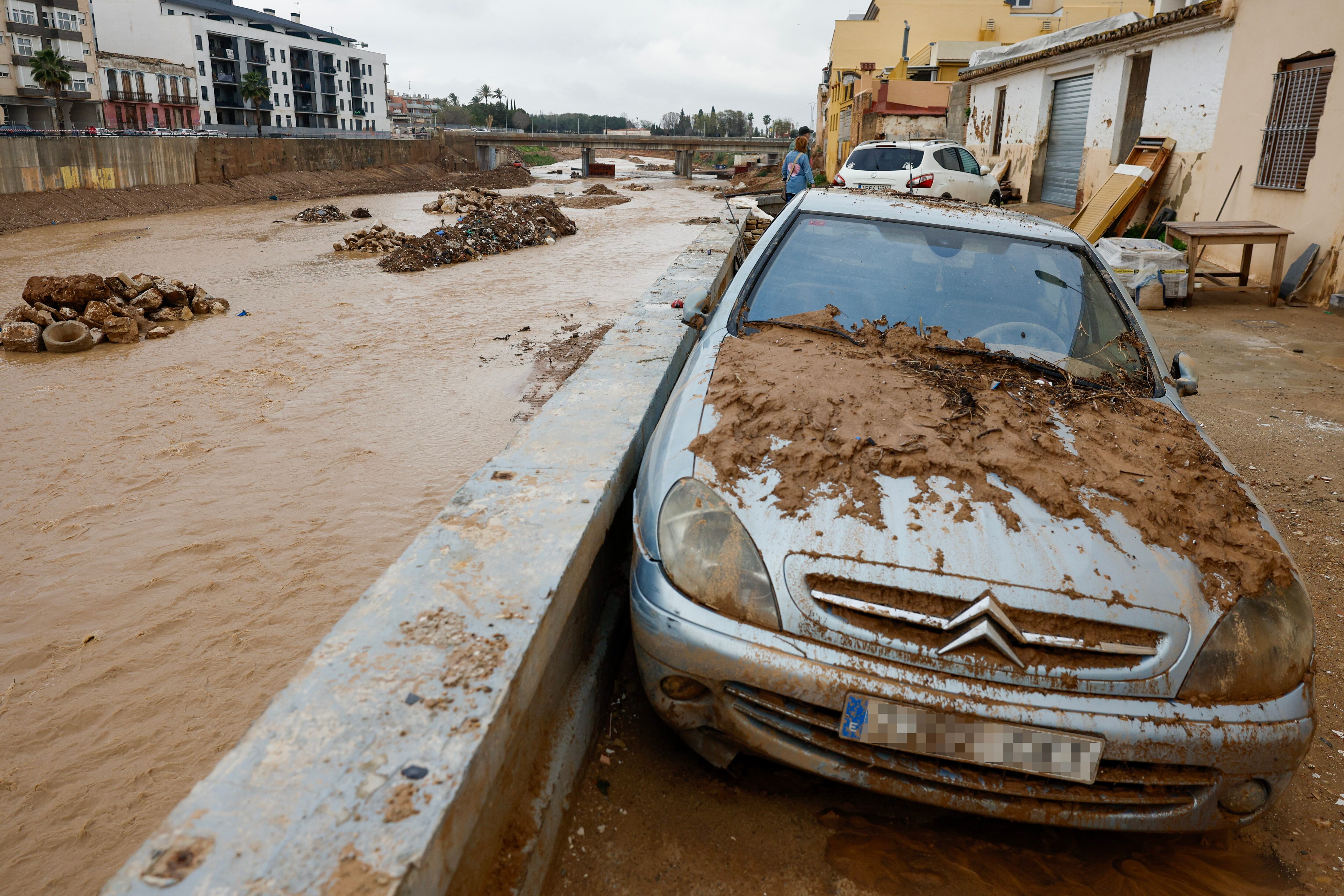 PAIPORTA (VALENCIA), 19/03/2025.- Vehículos cubiertos de barro e inmuebles destrozados junto al barranco del poyo este miércoles, en Paiporta. EFE/ Kai Forsterling

