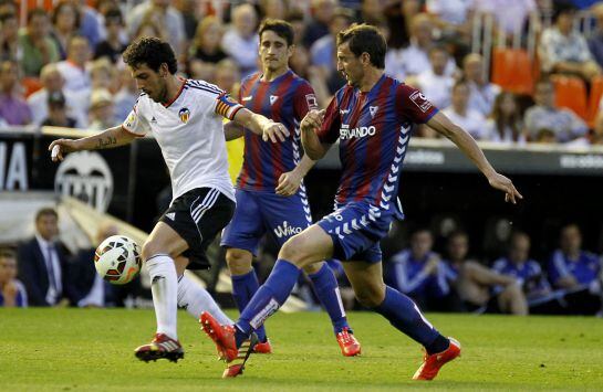Valencia&#039;s midfielder Dani Parejo (L) vies with Eibar&#039;s midfielder Saul Berjon during the Spanish league football match Valencia CF vs SD Eibar at the Mestalla stadium in Valencia on May 3, 2015. AFP PHOTO/ JOSE JORDAN