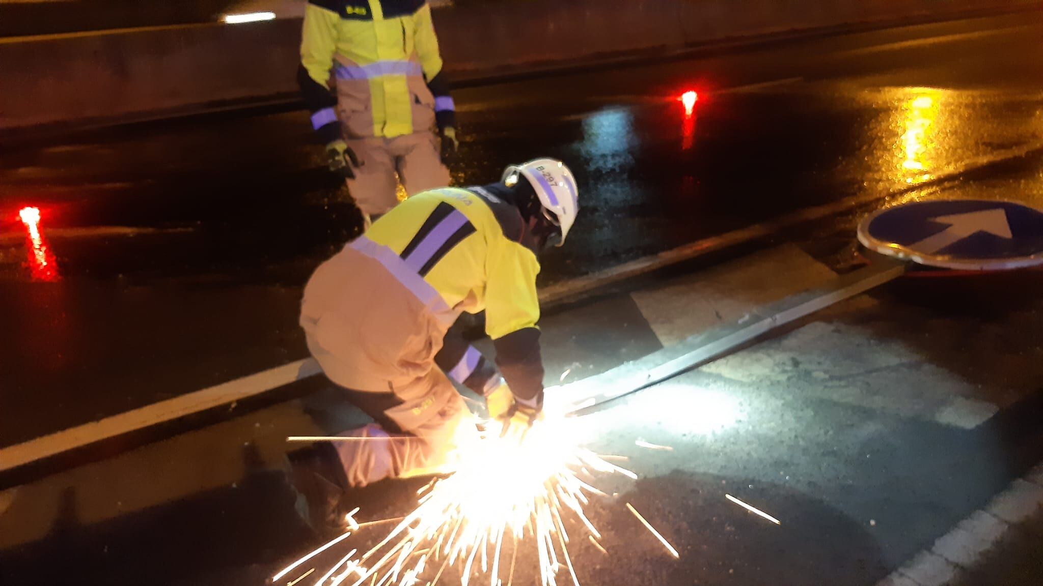 Los bomberos retiran una señal de tráfico tras el accidente