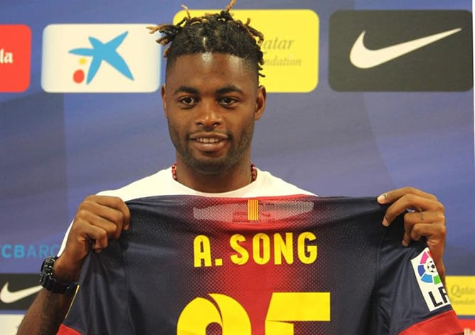 El centrocampista camerunés Alex Song muestra la camiseta con su nombre durante su presentación en las instalaciones del Camp Nou como nuevo jugador del FC. Barcelona para las próximas cinco temporadas