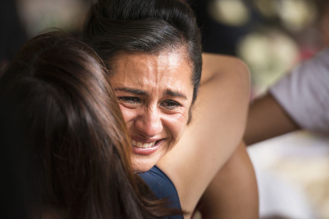 Una persona llora mientras otra la abraza