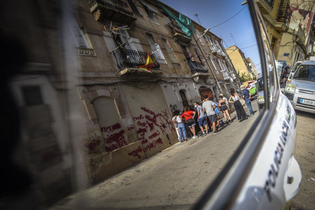 Personas ante los edificios de la Cruz Cubierta de València en riesgo de derrumbe. 