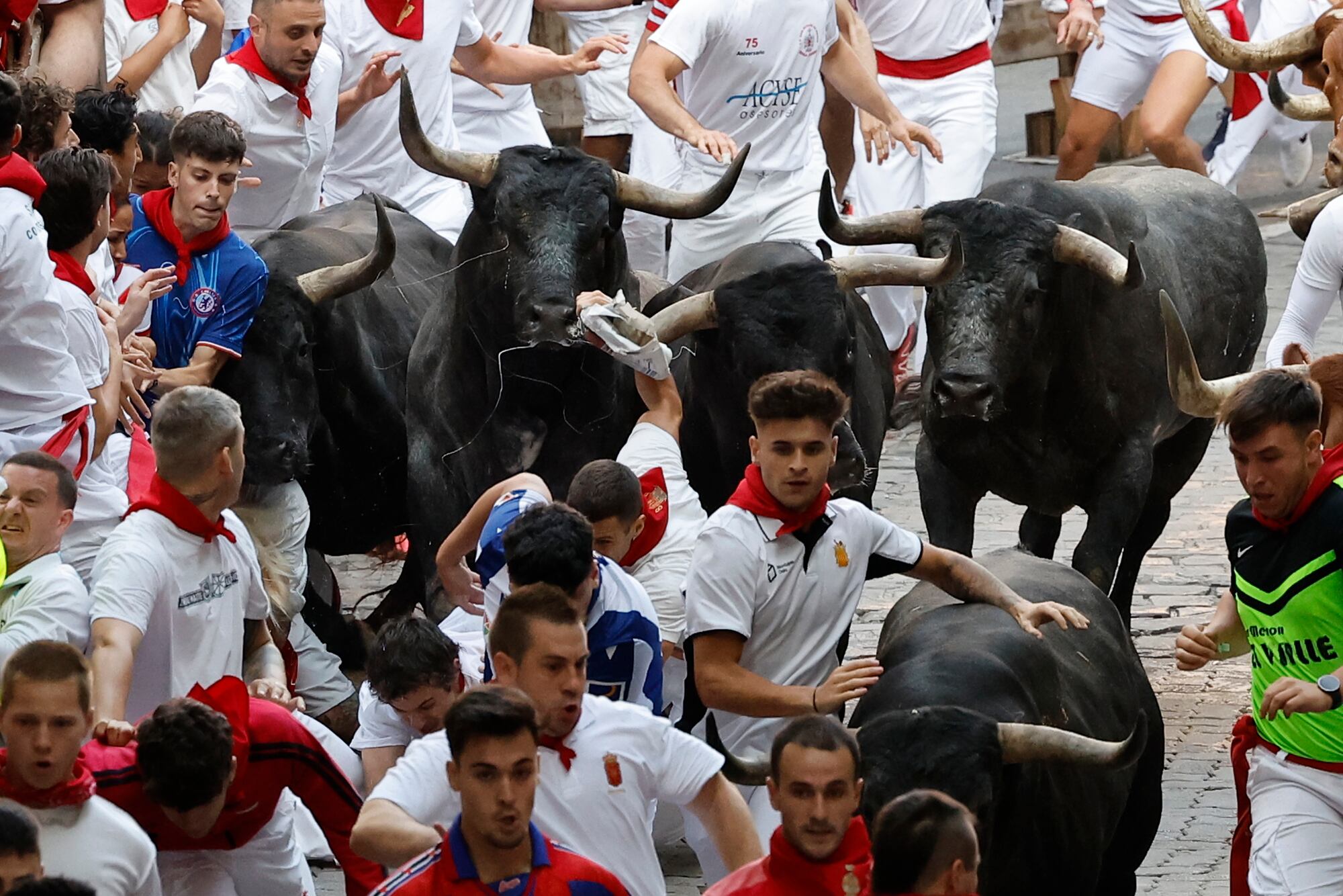 PAMPLONA, 14/07/2025.- Los mozos son perseguidos por toros de la ganadería sevillana de Miura durante el octavo y último encierro de los Sanfermines este lunes. EFE/ Villar López
