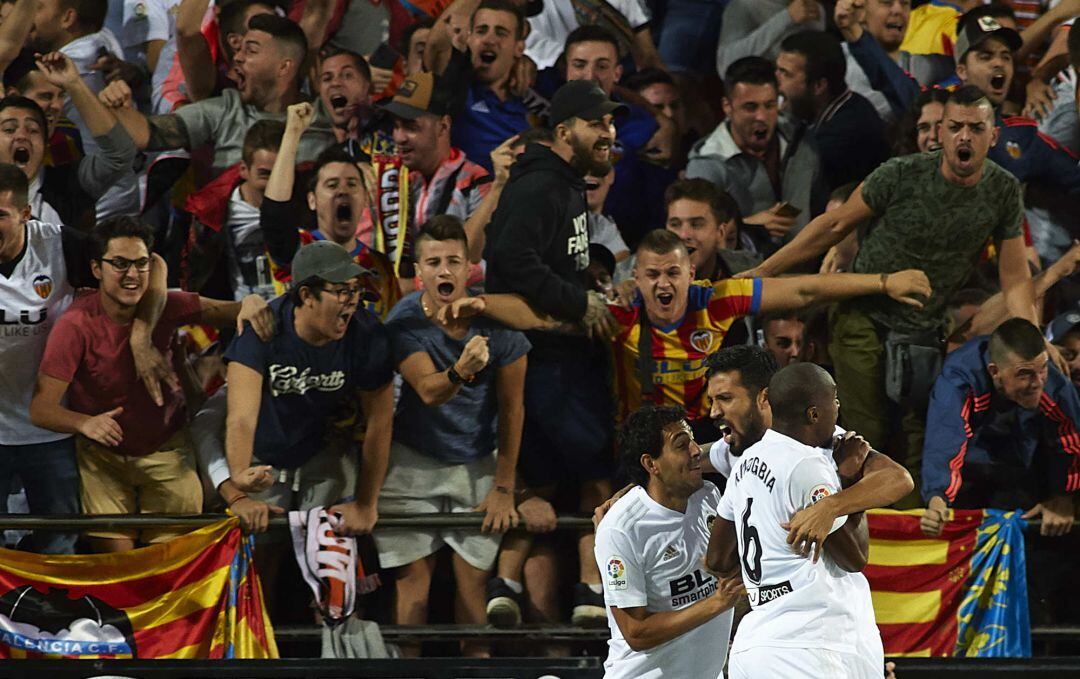 VALENCIA, SPAIN - OCTOBER 07:  Ezequiel Garay of Valencia celebrates after scoring his sides first goal with his teammates Daniel Parejo (L) and Geoffrey Kondogbia (R) during the La Liga match between Valencia CF and FC Barcelona at Estadio Mestalla on Oc
