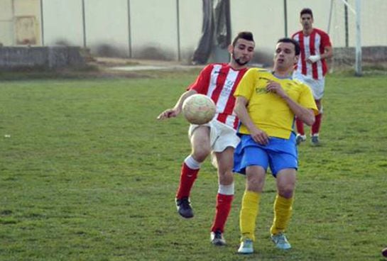 Cruz Benítez, con la camiseta rojiblanca, disputa un balón en un partido del Sporting Malpartida