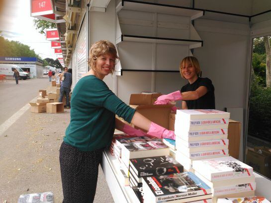 Isabel, librera (izquierda), y Donatella, editora (derecha), colocando los libros en su caseta el día antes de la inauguración