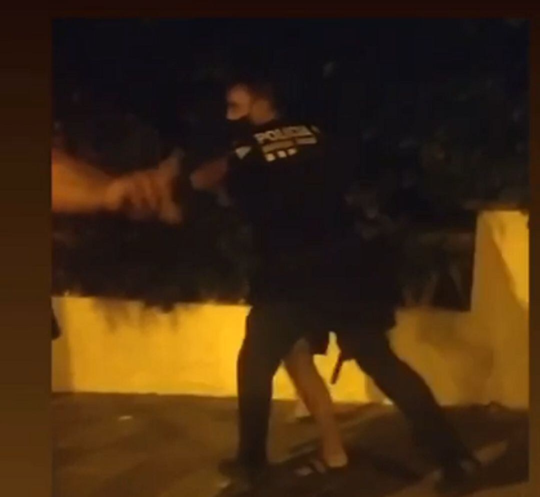 Un policia local retenint un dels nois