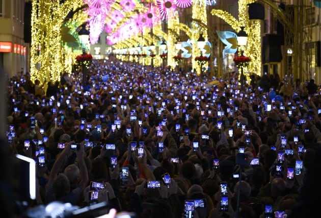 Decenas de móviles graban el encendido del alumbrado navideño de Málaga.