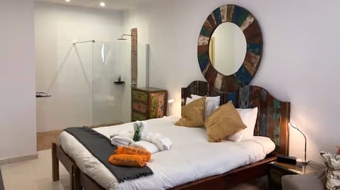 Cama y baño de un local comercial habilitado como apartamento en Costa Teguise, Lanzarote.